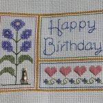 cross stitch happy birthday with hearts, flower and button