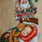 cross stitch dreams of christmas stocking. Boy sleeping with bear, santa toys, candy, holiday