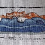 cross stitch I don't do mornings with cat sleeping on pillow bed