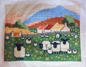 cross stitch pretty maids in a row with sheep, flowers and colorful hills