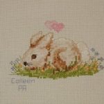 cross stitch charity quilt, rabbit sitting in grass with flowers and hearts