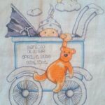 Cross stitch baby buggy Tobin. Baby in stroller with bear