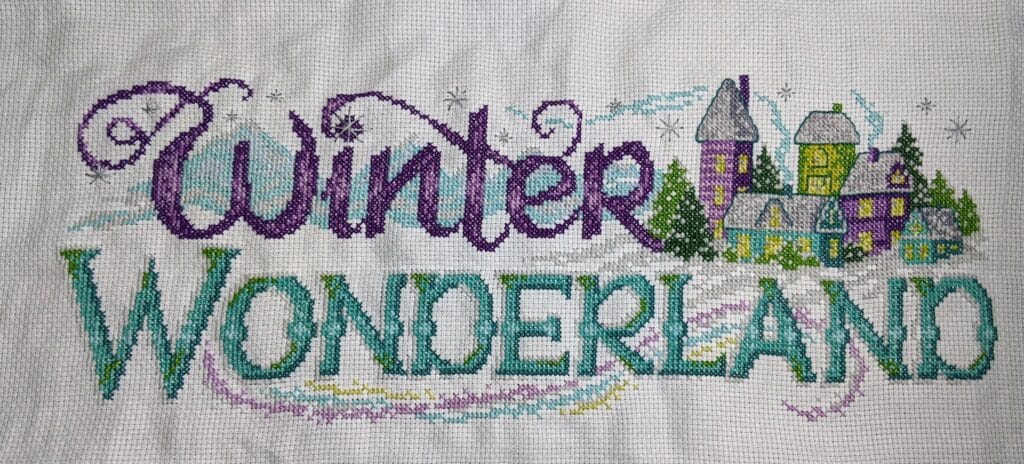 Cross stitch winter wonderland model stitching with words, houses, snow, christmas, holiday